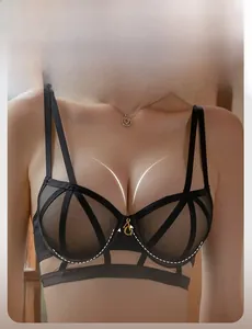 Detail view of black sheer mesh bra with underwire support and metal G pendant