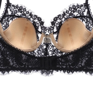 Dettaglio del reggiseno in pizzo nero con coppe color nudo e chiusura a doppio gancetto