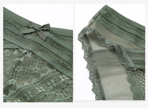 Detail of dark green lace panties featuring mesh fabric and a decorative ribbon bow