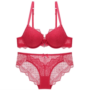 Detailed macro of a deep red lace lingerie set with fine mesh texture and bow charm