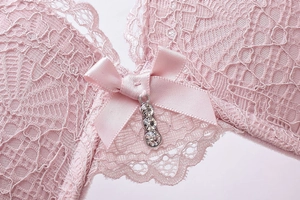 Detail of pink floral lace bra with a satin bow and shimmering rhinestone pendant