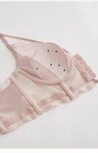 Detail view of pink lace bra cup showing thin lining and seamless wireless structure