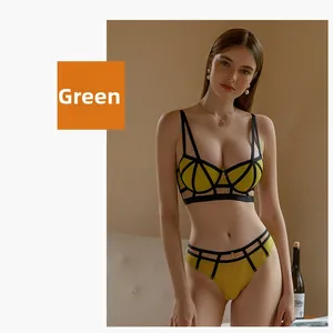 Detailed view of green mesh lingerie set with black straps and golden brand letter hardware