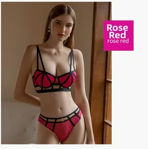Detail shot of rose red lace bra with black strappy cage design and letter G pendant