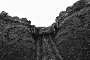 Macro shot of delicate black lace embroidery and satin bow detail on a French style bra