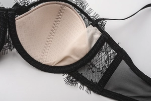 Close-up of black eyelash lace bra with breathable nude lining and mesh wing detail