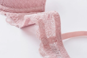 Detail of pink floral lace embroidery and fine shoulder strap on deep V bra set
