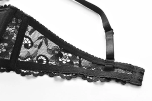 Close-up of black floral lace bra showing adjustable straps and scalloped edge detail