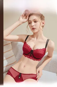 Detail of red lace lingerie set with black bow accents and sheer floral embroidery