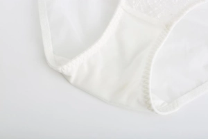 Detail of white lace panties showing breathable mesh fabric and cotton crotch lining