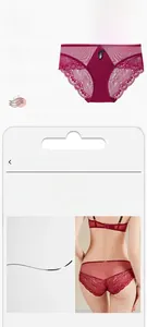 Detail view of wine red lace panties featuring a black bow and metallic pendant
