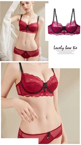 Detail of red lace lingerie set with black bow accents and delicate floral embroidery
