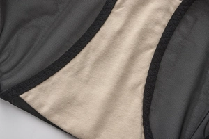 Detailed macro shot of French black eyelash lace and soft beige mesh fabric on bra cup