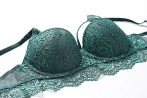 Dettaglio ravvicinato del reggiseno in pizzo verde scuro con bordo smerlato
