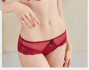Detailed view of red lace lingerie featuring semi-transparent mesh and black bow detail