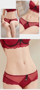 Close-up of red floral lace lingerie set with black bow detail and metal charms
