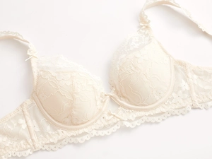 Détail macro du soutien-gorge français en dentelle florale ivoire aux bords festonnés