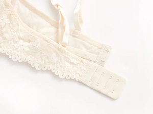 Vue macro détaillée de la dentelle beige brodée et de la fermeture à quatre rangées