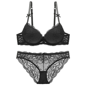 Close-up of black floral lace lingerie set with bow details and scalloped mesh edges