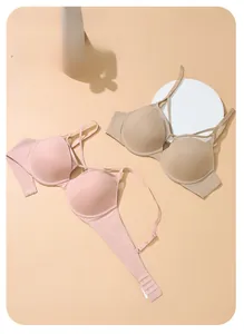 Detailed view of seamless soft cup bras with elegant cross-strap accents in pastel tones