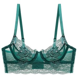 Detail of dark green lace bra showing delicate floral embroidery and sheer mesh texture