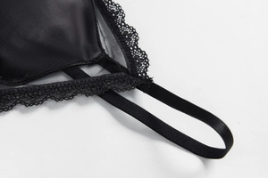 Close-up of smooth black satin fabric and delicate eyelash lace details on bra