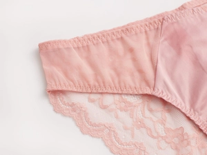 Close-up van lichtroze kant en satijnen stof van Franse stijl dames lingerie setje