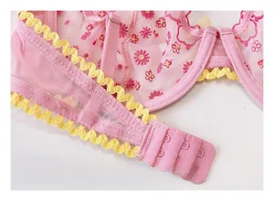 Dettaglio reggiseno in mesh rosa con ricami floreali e chiusura posteriore a tre file