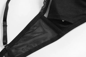 Macro detail of black lace trim, mesh fabric, and adjustable straps on a wireless bra
