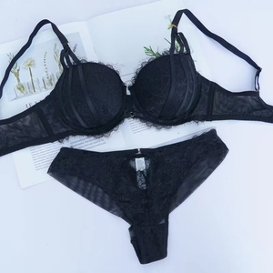 Completo intimo in pizzo ciglia nero con dettagli a cinturino su sfondo bianco