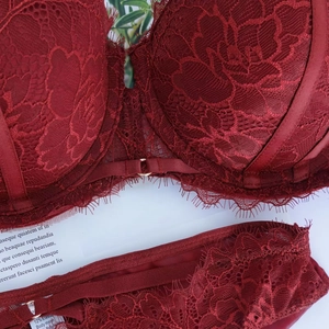Vista macro dettagliata del set di lingerie in pizzo rosso scuro con ricami