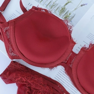 Dettaglio del reggiseno in pizzo bordeaux con texture floreale e fodera in rete morbida