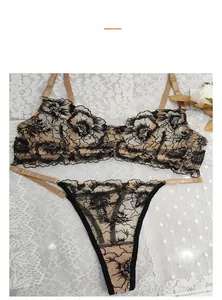 Dettaglio di pizzo floreale nero su set lingerie beige con fibbie in metallo oro