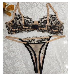 Dettaglio del ricamo floreale beige sul reggiseno in rete e il set perizoma a T