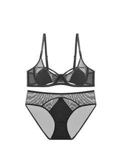 Detail of black sheer mesh and lace lingerie set with elegant golden metal ring accents