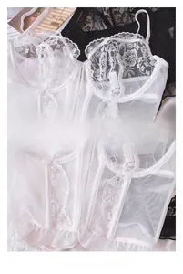 Detail view of white floral lace corset lingerie with fishbone structure and mesh panels