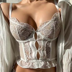 White lace corset top with floral embroidery and ruffle hem in natural lighting