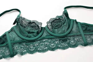 Close-up of dark green floral lace bra showing semi-sheer mesh and delicate embroidery