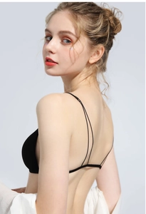 Detail view of minimalist black bralette featuring ultra-thin double back straps on a model