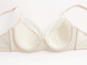 Close-up of elegant beige lace bra featuring floral patterns and underwire support