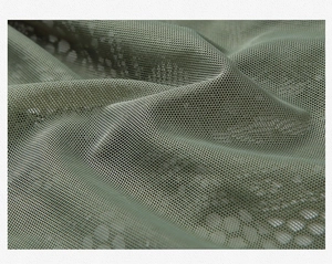 Makrodetail aus olivgrünem Spitzenstoff mit zartem Blumenmuster und Sechseck-Maschenstruktur