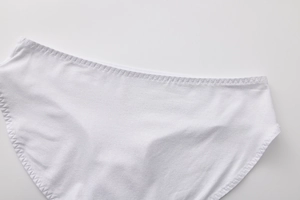 Dettaglio dell'intimo in cotone bianco che mostra la consistenza del tessuto e le cuciture