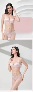 Detailed view of pale pink lace lingerie set with white floral embroidery and mesh details