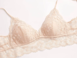 Detailaufnahme des rosa Spitzen-BHs mit Blumenmuster und feiner Bogensaum-Stickerei