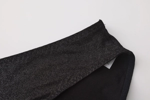 Dettaglio del tessuto nero con glitter argento ed etichetta della taglia M