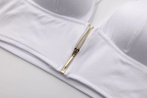 Dettaglio del reggiseno bianco senza ferretto con cerniera frontale dorata e tessuto morbido