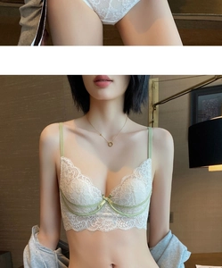 Détail de lingerie en dentelle florale blanche avec passepoil vert et nœuds élégants