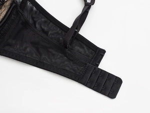 Détail de la fermeture à trois agrafes et bretelles réglables sur le soutien-gorge noir