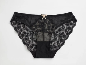 Gros plan détaillé sur la dentelle noire complexe et le petit nœud beige du slip femme