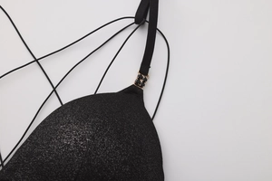 Dettaglio in tessuto nero scintillante con fibbia dorata su reggiseno francese